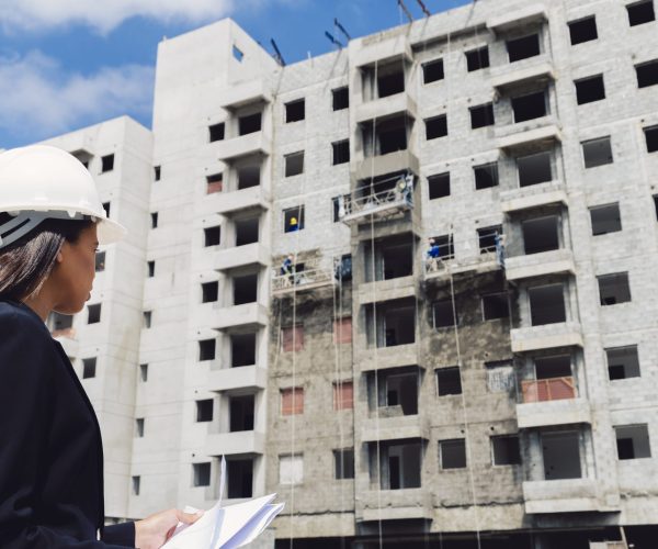 dama-afroamericana-en-casco-de-seguridad-con-papeles-cerca-del-edificio-en-construccion